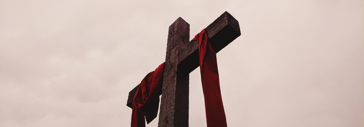 low angle view of cross with red garment
