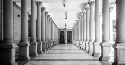 grayscale photo of hallway with columns